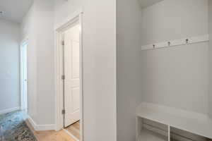 Mudroom featuring light wood-type flooring and baseboards