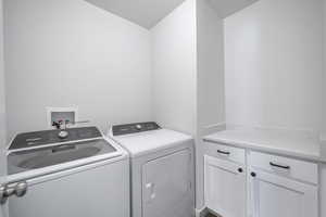 Laundry room featuring washing machine and clothes dryer and cabinet space