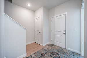 Foyer with light wood-style floors and baseboards