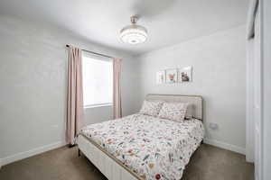 Bedroom featuring carpet floors and baseboards