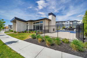 Exterior space with fence, stucco siding, a community pool, and a residential view