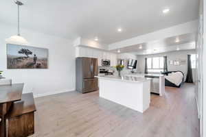 Kitchen with appliances with stainless steel finishes, light countertops, white cabinetry, light wood-style floors, and recessed lighting