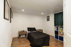 Bedroom with wood finished floors, baseboards, and recessed lighting