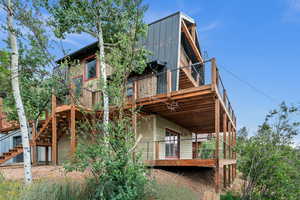 Back of house with stairway and a deck