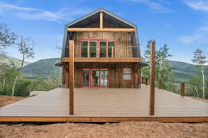 Back of property featuring a deck with mountain view