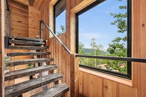Staircase featuring wood walls