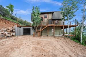 View of front of house with driveway, stairway, a deck, and an attached garage