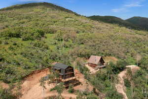 Aerial view of property and surrounding area with a forest and mountains