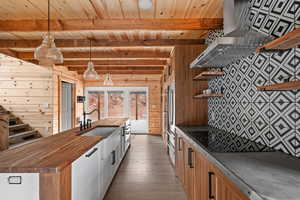 Kitchen featuring open shelves, wooden counters, wooden ceiling, wooden walls, and hardwood / wood-style floors