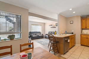 Kitchen with dishwasher, recessed lighting, crown molding, light countertops, and a peninsula