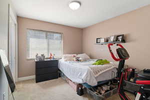 Carpeted bedroom with a closet and baseboards
