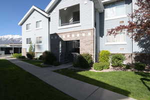 View of front of house with a front yard and brick siding