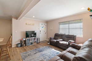Living room featuring crown molding, wood finished floors, recessed lighting, and baseboards