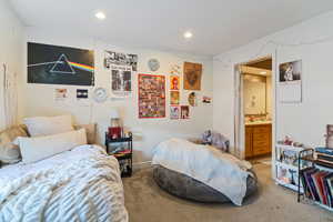 Bedroom featuring light colored carpet, recessed lighting, and connected bathroom