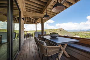 Deck with outdoor dining area and a mountain view