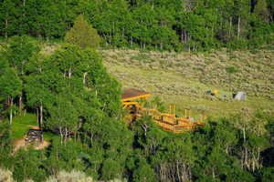 Aerial view of property and surrounding area with a heavily wooded area