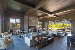 Living area featuring wood walls, wood ceiling, coffered ceiling, hardwood / wood-style flooring, and beam ceiling