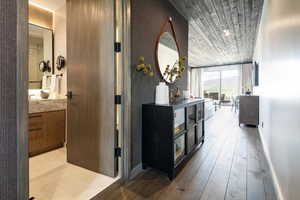 Corridor with expansive windows, wood ceiling, light wood finished floors, and baseboards