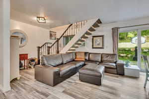 Living area featuring stairs and wood finished floors