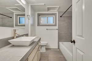 Full bathroom featuring vanity, a textured ceiling, visible vents, and toilet