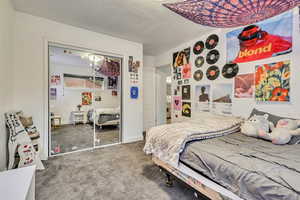 Carpeted bedroom with a closet and baseboards