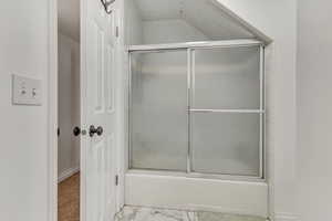 Full bathroom featuring bath / shower combo with glass door