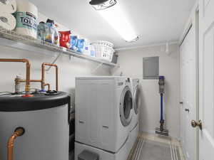 Laundry room featuring water heater, separate washer and dryer, light tile patterned floors, and electric panel