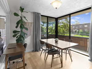 Dining space with light wood finished floors, a textured ceiling, and baseboards