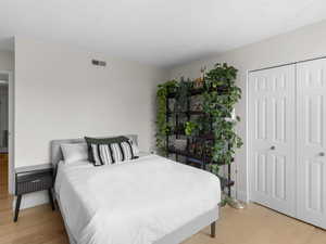 Bedroom with a closet, baseboards, and light wood-style floors