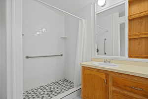 Bathroom featuring a shower stall and vanity