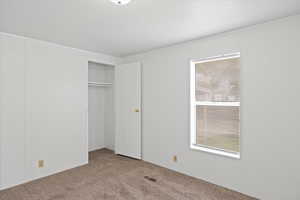 Unfurnished bedroom with carpet floors and a closet