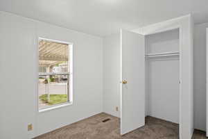 Unfurnished bedroom with carpet flooring and a closet
