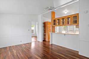Unfurnished living room with dark wood-type flooring