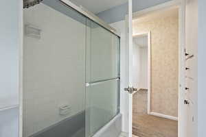 Full bath with combined bath / shower with glass door
