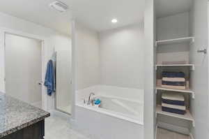 Full bathroom featuring a shower stall, a bath, tile patterned flooring, and vanity
