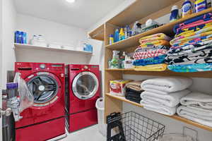 Laundry area with independent washer and dryer and tile patterned flooring