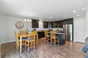 Dining space with a chandelier, recessed lighting, baseboards, and light wood finished floors