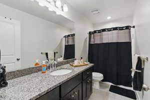 Full bath with tile patterned floors, toilet, vanity, a shower with curtain, and recessed lighting