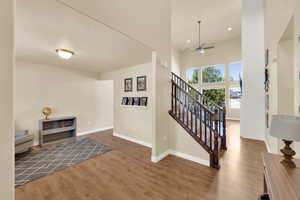 Foyer with wood finished floors, ceiling fan, baseboards, stairs, and recessed lighting