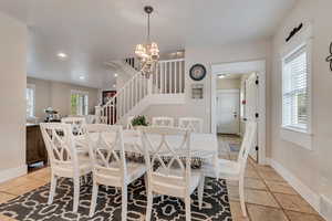 Dining space with stairway, a chandelier, baseboards, and recessed lighting