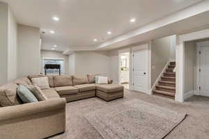 Carpeted living area with stairway, recessed lighting, and baseboards