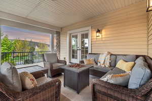 Patio terrace at dusk featuring an outdoor living space with a fire pit and french doors