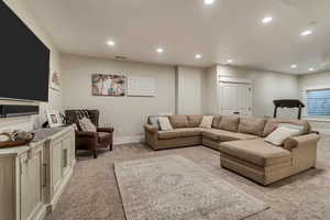 Living area featuring light colored carpet, recessed lighting, and baseboards