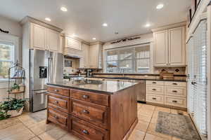 Kitchen featuring appliances with stainless steel finishes, cream cabinetry, backsplash, healthy amount of natural light, and recessed lighting