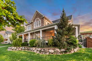 View of front of property featuring stone siding and covered porch