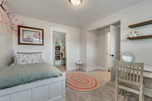 Bedroom featuring light colored carpet, baseboards, and a closet