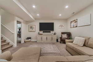 Living area with light colored carpet, stairway, baseboards, and recessed lighting
