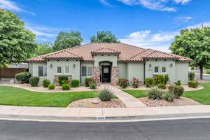Mediterranean / spanish-style home featuring stucco siding, a tile roof, and stone siding