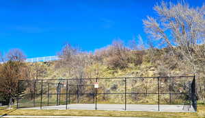 Exterior space featuring community basketball court and fence