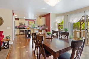 Dining space with wood finished floors, recessed lighting, baseboards, and a chandelier